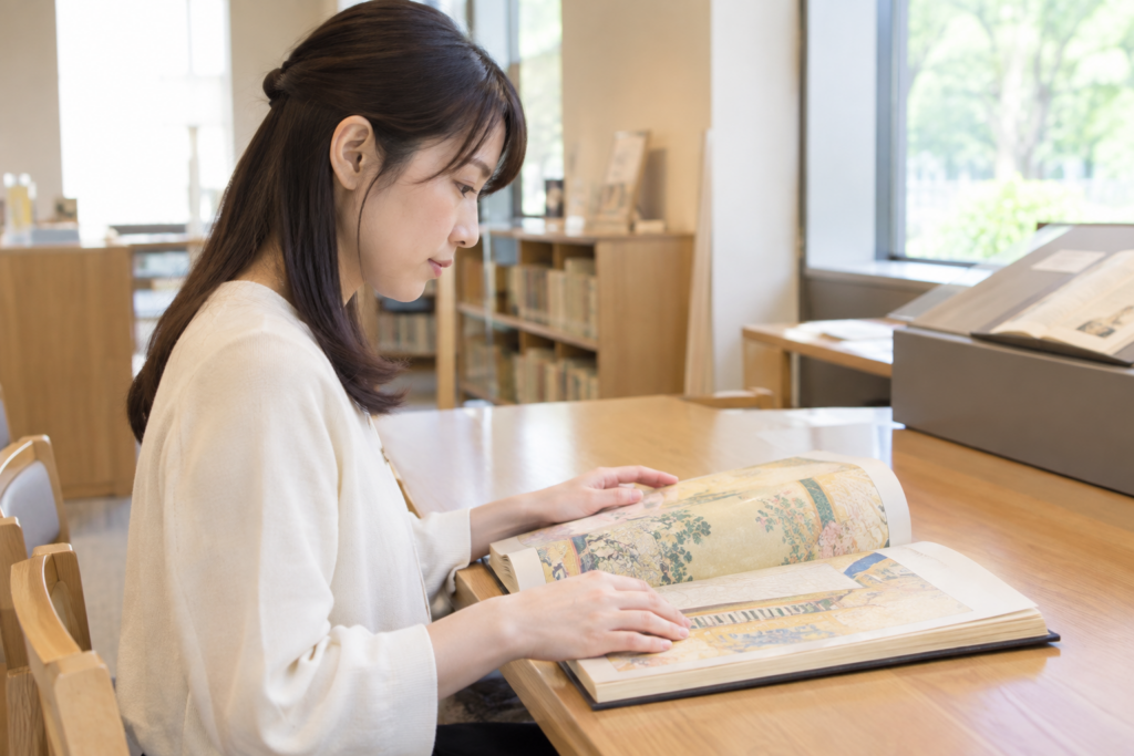 図書館で女性が本をめくって読んでいる