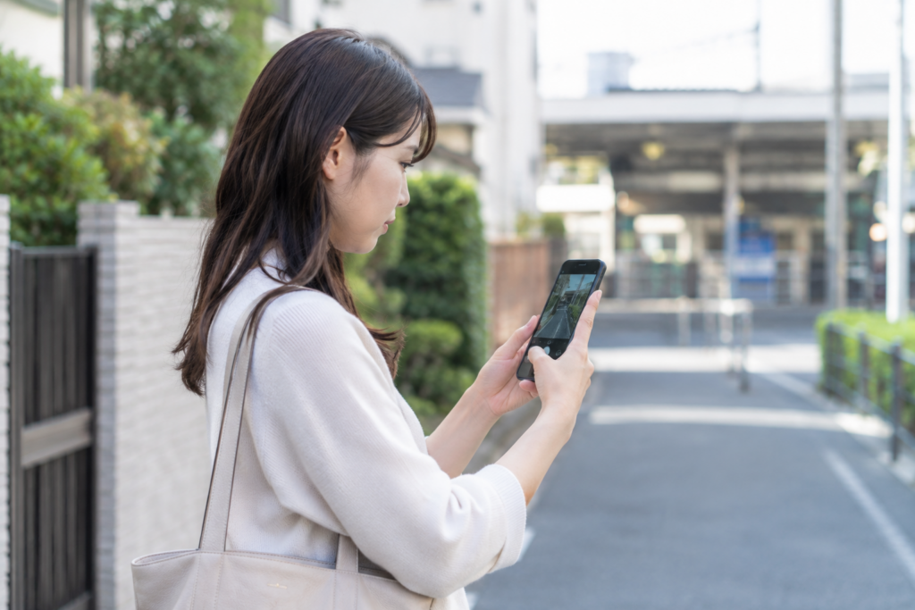 屋外で女性がスマートフォンを見ている