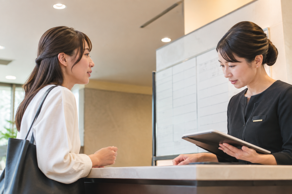 店内のカウンターで、女性客がスタッフに相談している様子
